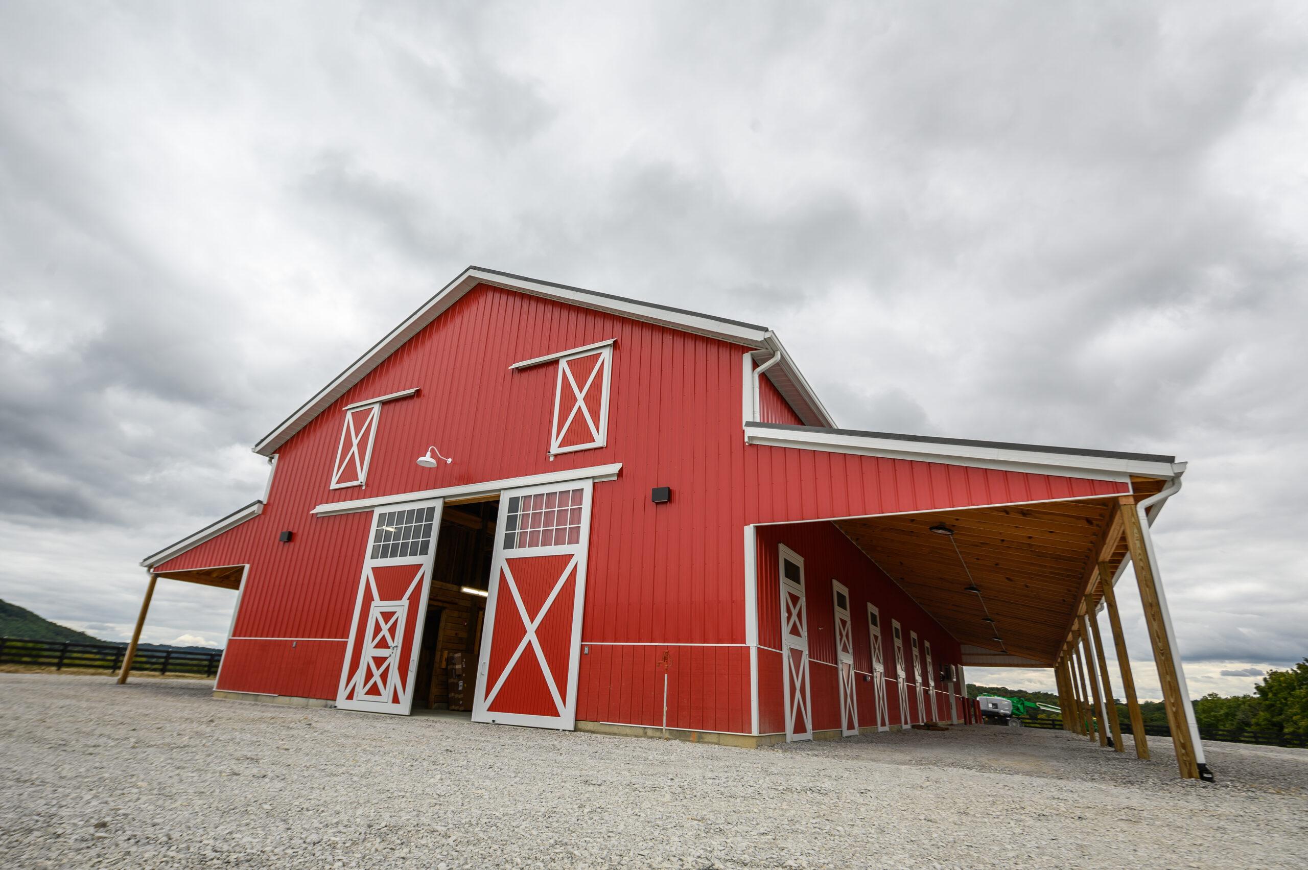 A picture of the new horse barn from the outside. The barn is red.